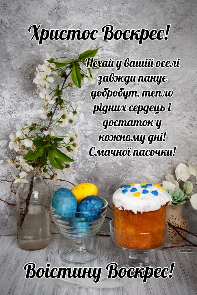 Великодні яєчка та пасочка з квітами на дерев'яному столі.