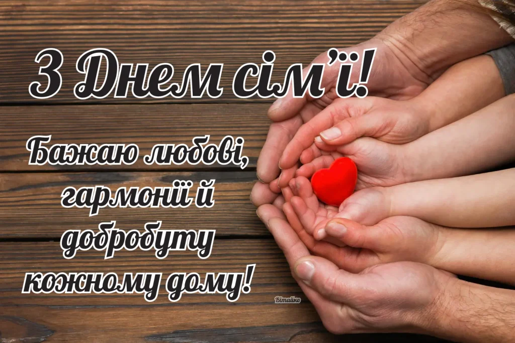 Ручки тримають червоне серце на дерев'яному фоні.