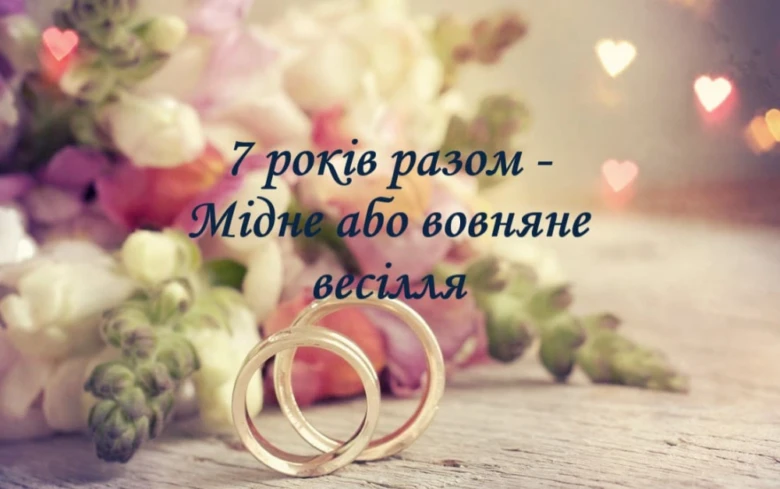 Два золоті кільця на квітах з привітанням до сьомої річниці весілля.