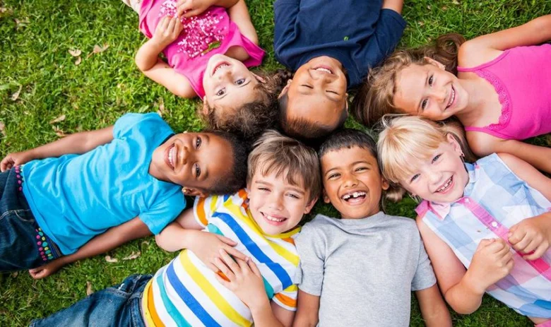 Group of happy children lying on grass
