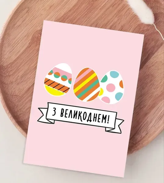 Розписані великодні яйця на рожевій листівці з привітанням.
