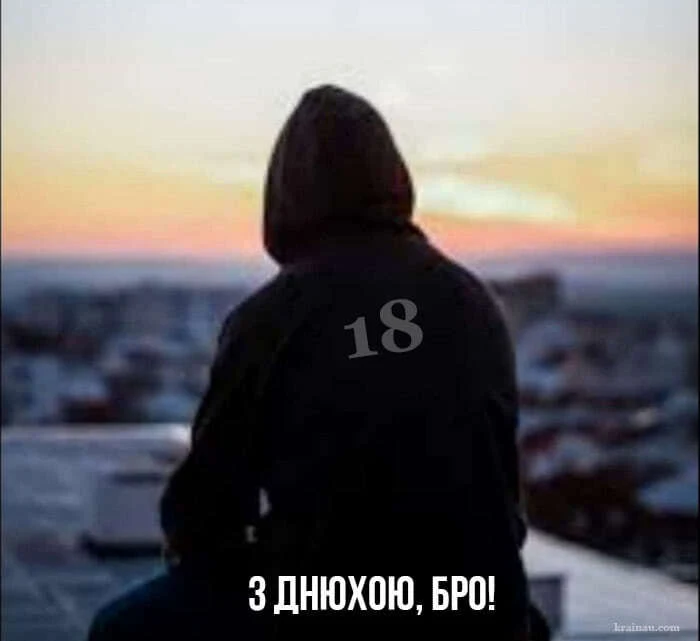 Чоловік у капюшоні на даху з написом 18 та привітанням українською.
