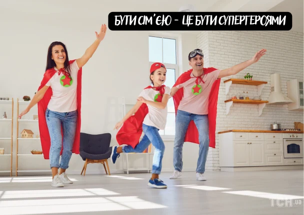 Сім'я в супергероях святкує разом у світлій кухні.
